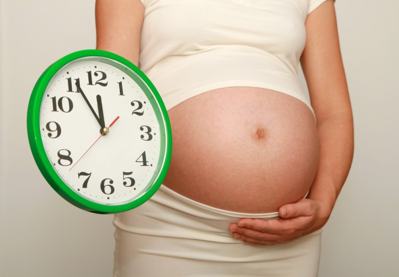беременная с часами в руках