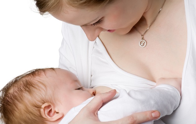 Молодая мамочка кормит грудью новорожденного ребенка