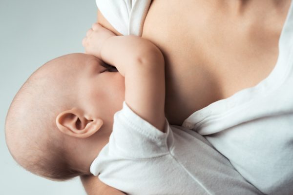 женщина кормит ребенка грудью